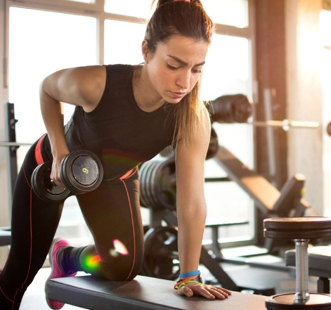 Fitness girl lifting dumbbell